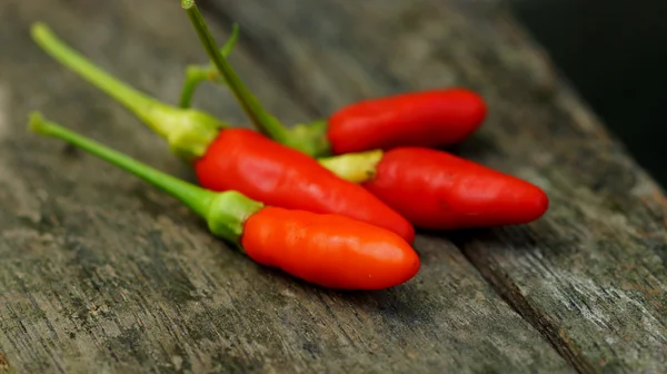 Fresh green and red peppers and spicy on wooden floors. — Stock Photo, Image