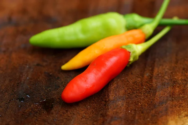 Fresh green and red peppers and spicy on wooden floors. — Stock Photo, Image