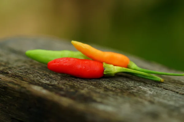 Pimientos verdes y rojos frescos y picantes en pisos de madera . —  Fotos de Stock