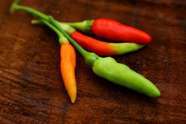 Pimientos verdes y rojos frescos y picantes en pisos de madera . —  Fotos de Stock