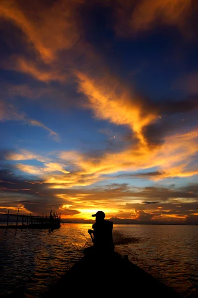 Hommes solitaires silhouettes sur le coucher du soleil ciel belle lagune — Photo