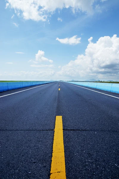 Céu azul com poderia, estrada vazia e as linhas de tráfego . — Fotografia de Stock
