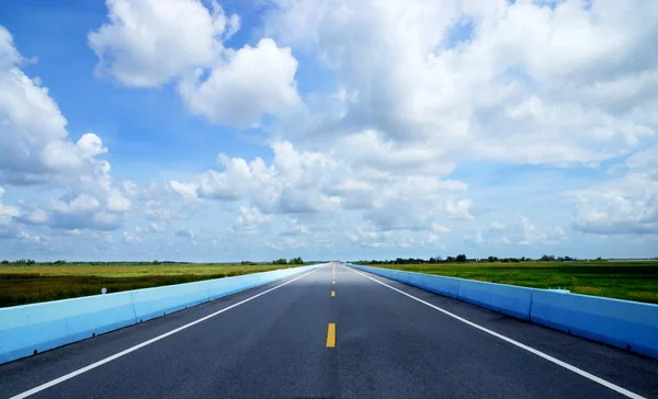 Blauwe lucht met kan lege weg en het verkeer lijnen. — Stockfoto