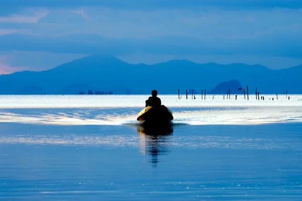 Pêche dans le lac Assis dans un bateau au crépuscule — Photo