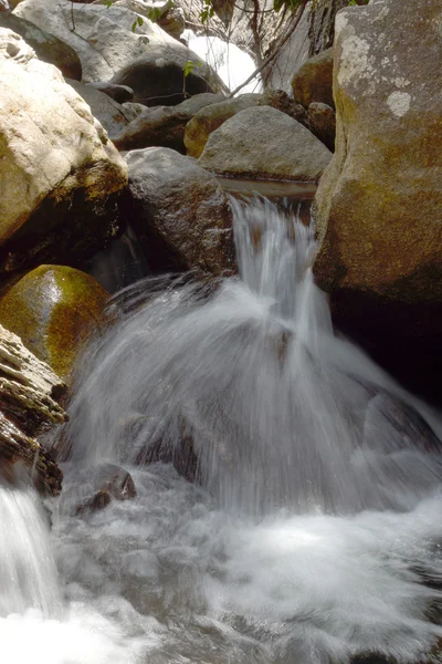 Air terjun kecil mengalir di atas batu . — Stok Foto