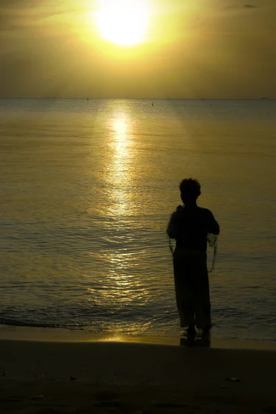 Silhouettes of fishermen along the beach. — Stock Photo, Image