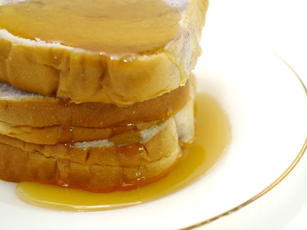 Pan y miel en plato, aislados en blanco — Foto de Stock