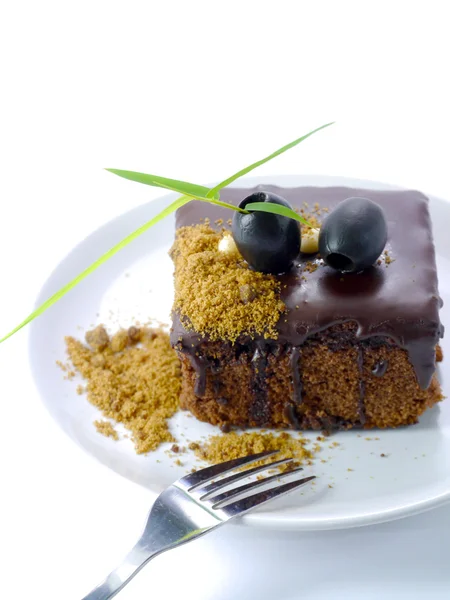 Pastel de chocolate con aceitunas negras sobre fondo blanco aislado — Foto de Stock