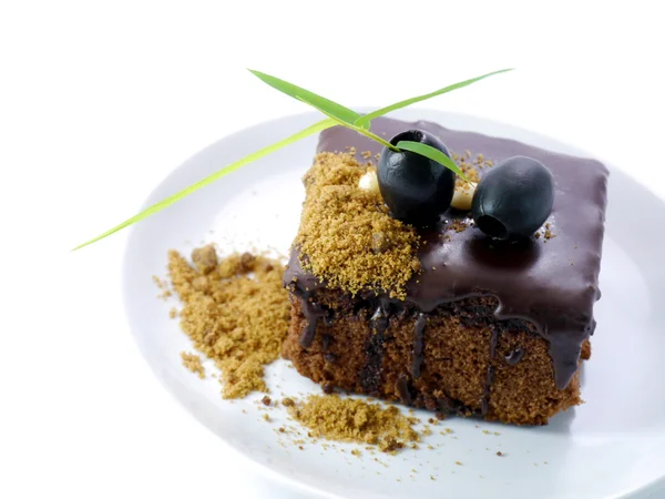Chocolate cake met zwarte olijven op witte geïsoleerde achtergrond — Stockfoto