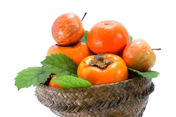 Pomarańcza, jabłko i persymona w koszyku papirusu. — Zdjęcie stockowe
