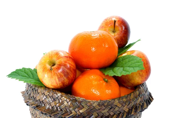 Apelsin, äpple och persimon i papyruskorgen. — Stockfoto