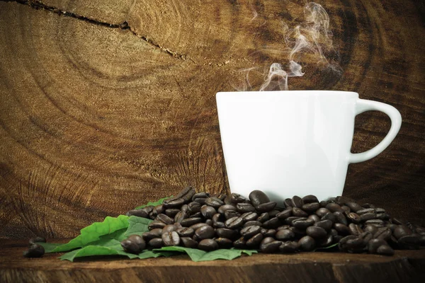Café e grãos no fundo de madeira . — Fotografia de Stock
