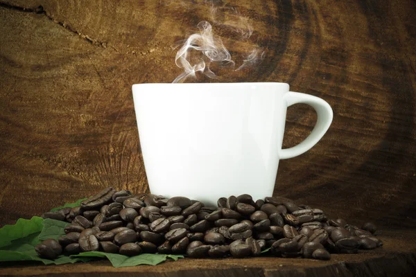 Café e grãos no fundo de madeira . — Fotografia de Stock