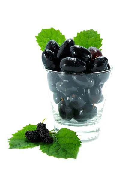 Black grapes in a glass isolated on a white background. — Stock Photo, Image