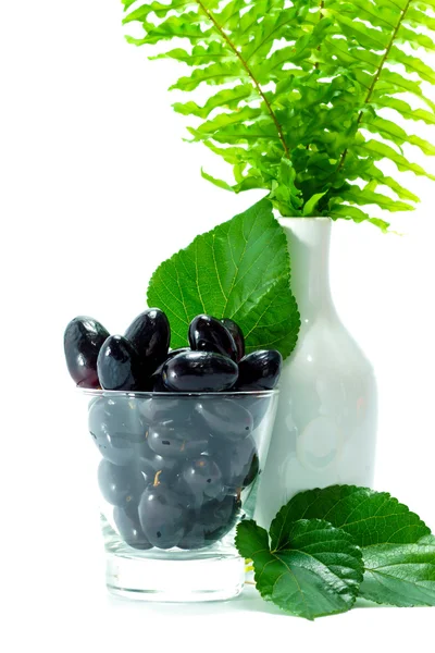 Black grapes in a glass isolated on a white background. — Stock Photo, Image