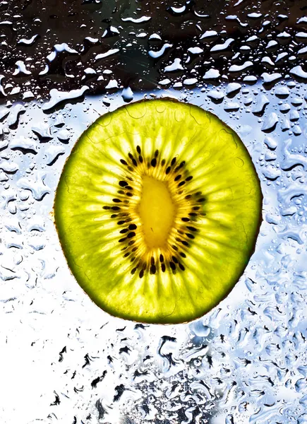 Kiwi en water druppels op glas. — Stockfoto