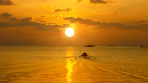 Silhouette of local small fishing boat moving to sunset. — Stock Photo, Image