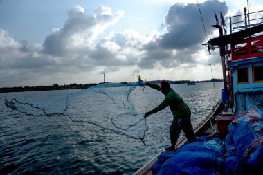 Yengeç teknesinde döküm siluetleri balıkçı.