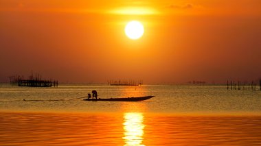 gün batımında göl ve balıkçı tekneleri.