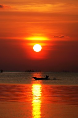 gün batımında göl ve balıkçı tekneleri.