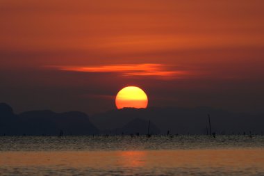 günbatımı gökyüzü ve göl üzerinde büyük güneş.