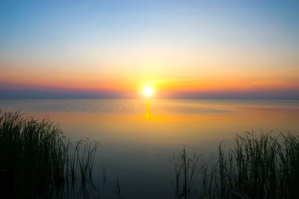 Закатное небо и солнце над озером . — стоковое фото