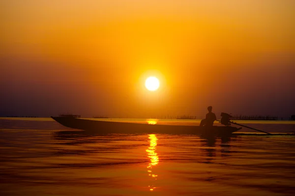 シルエットの漁師と湖の夕日. — ストック写真
