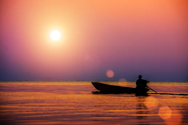 Silhouetten visser en zonsondergang op het meer. — Stockfoto