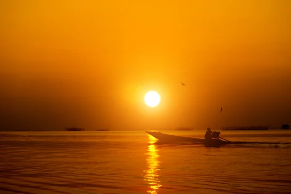 Silhuetas pescador e pôr do sol no lago . — Fotografia de Stock