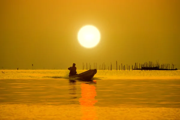 Silhuetas pescador e pôr do sol no lago . — Fotografia de Stock