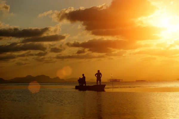 Siluetas pescador y puesta de sol en el lago . — Foto de Stock