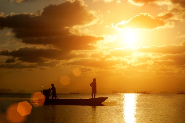 Siluetas pescador y puesta de sol en el lago . — Foto de Stock