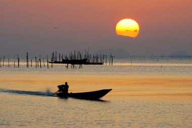 günbatımı gökyüzü ve göl üzerinde büyük güneş.