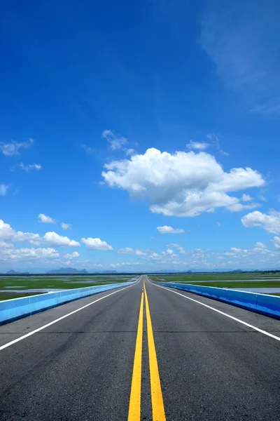 Estrada vazia e as linhas de trânsito amarelas com céu azul . — Fotografia de Stock