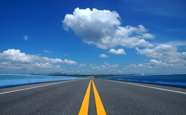 Empty road and the yellow traffic lines with blue sky. — Stock Photo, Image