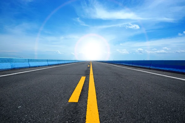 Empty road and the yellow traffic lines with blue sky. — Stock Photo, Image