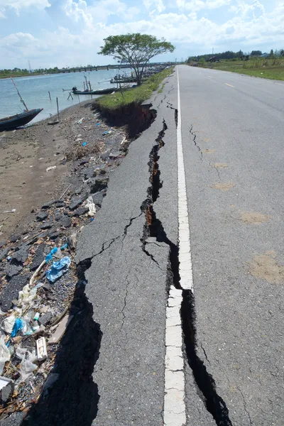 Szczeliny i erozji asfaltową drogą przez trzęsienie ziemi. — Zdjęcie stockowe