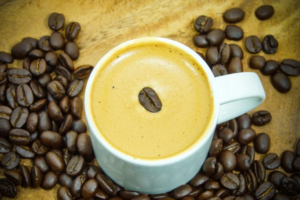 Koffie en koffie bean op hout achtergrond — Stockfoto