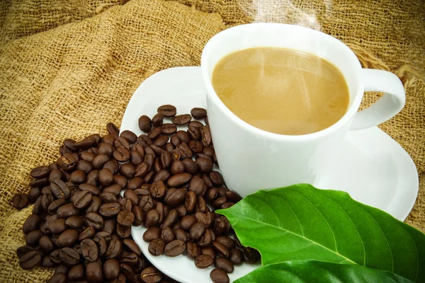 Кава і кавові зерна на тканині ручної роботи . — стокове фото