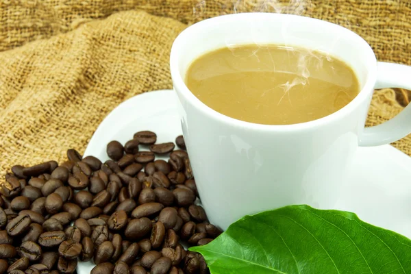 Kaffee und Kaffeebohnen auf handgemachtem Stoff. — Stockfoto