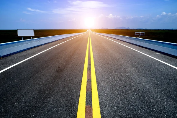 Empty road and the yellow traffic lines with blue sky. — Stock Photo, Image