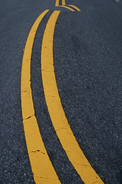 Kaksi keltaista liikennelinjaa. Tien päällä . — kuvapankkivalokuva
