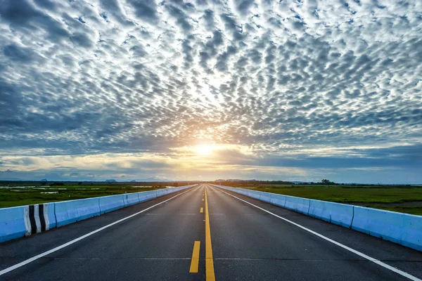 Empty road and the yellow traffic lines with clouds. — Stock Photo, Image