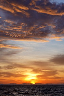 Göl kenarında gün batımı gökyüzü arka planında bulutlarla.