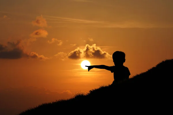 Siluet Seorang Anak Laki Laki Menunjuk Matahari Bukit Dengan Matahari — Stok Foto