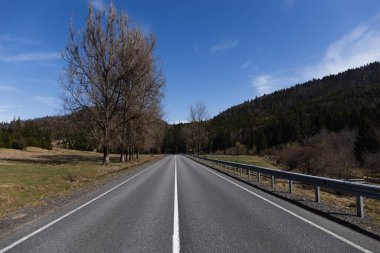 Boş yol, dağlar ve gökyüzü arka planda
