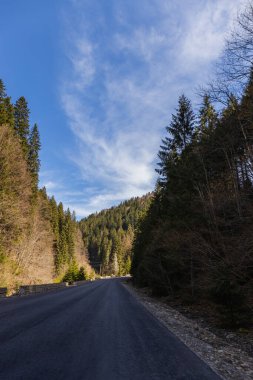 Arkaplanda mavi gökyüzü ve dağları olan boş bir yol 