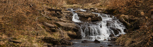 Mountain creek in forest in autumn, banner 