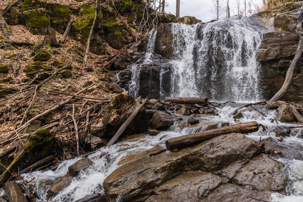 Wooden logs on stones near mountain creek 