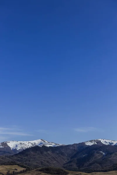 Landscape with mountains with snow and blue sky at background